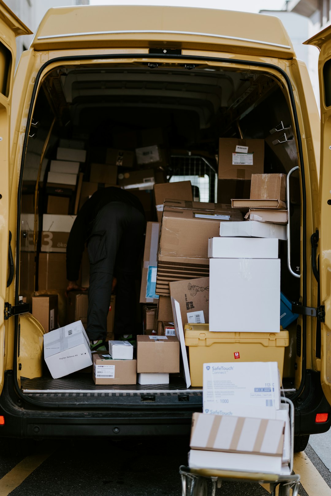 Οδηγός courier φορτώνει δέματα σε βαν για διανομές στη Γερμανία